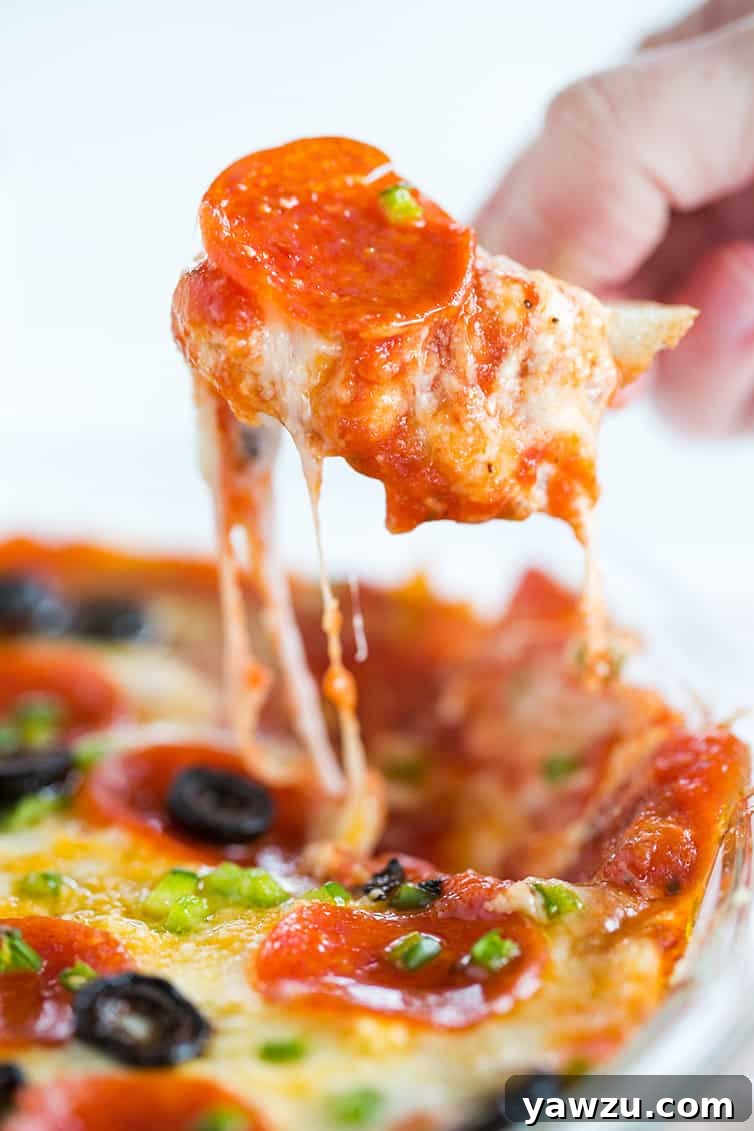 Scooping up pizza dip with a chunk of bread.