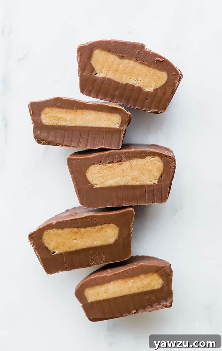 Multiple peanut butter cups cut in half, lined up, cut side up.