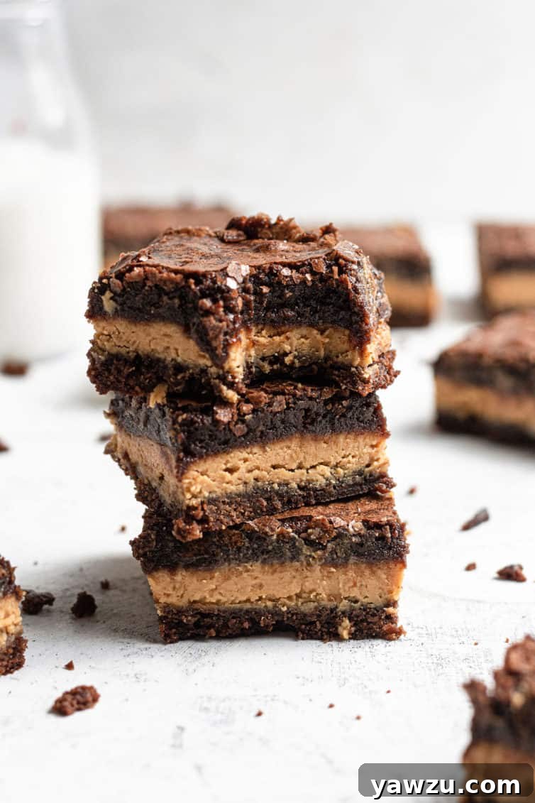 A stack of peanut butter brownies with a bite taken out of the top one.