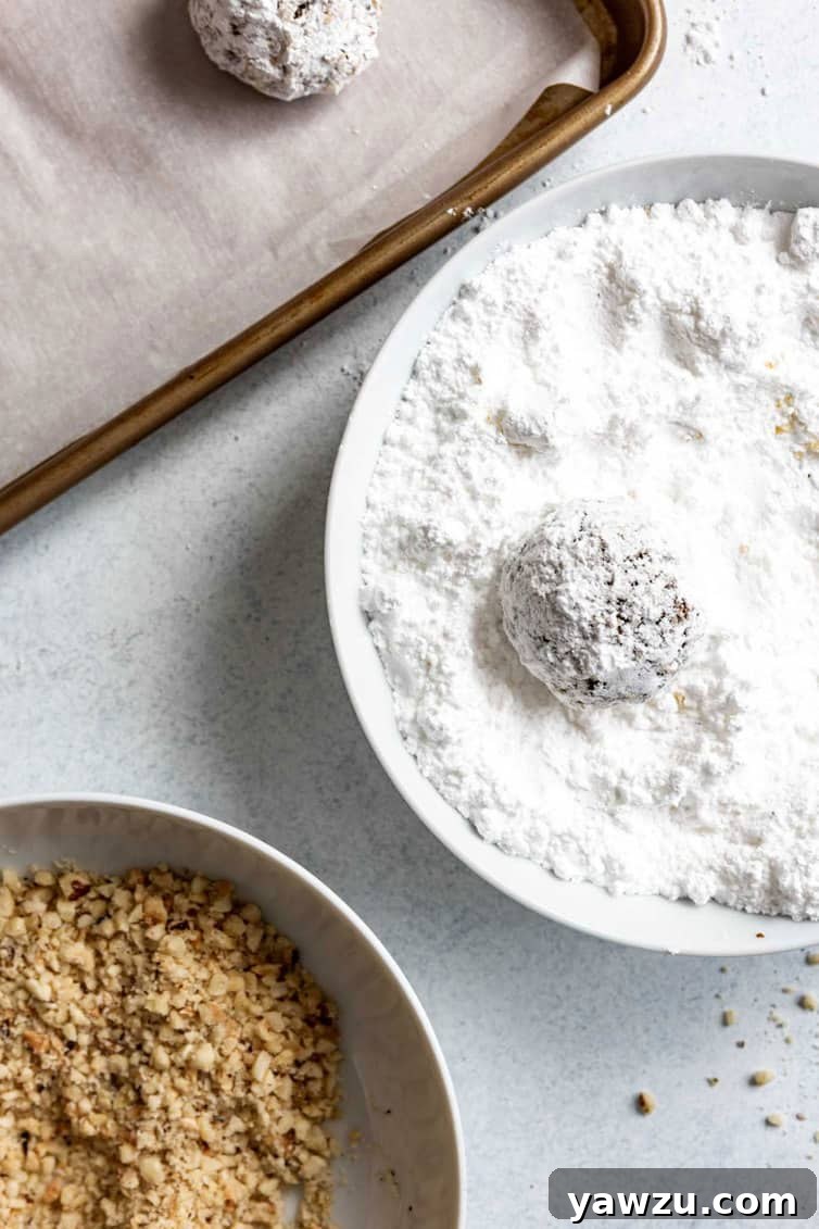 Rolling Nutella cookie dough ball in powdered sugar.