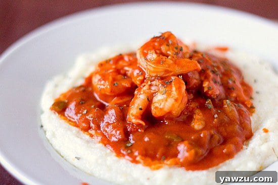 A vibrant and flavorful bowl of Creole Shrimp and Grits garnished with fresh herbs