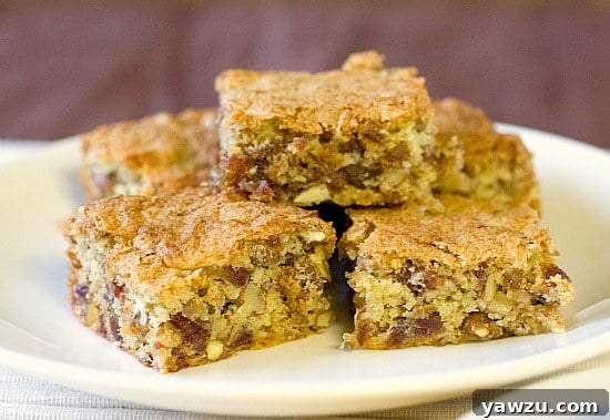 A close-up view of freshly baked date bars, highlighting the rich texture of dates and pecans baked within.