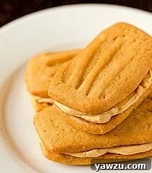 3 peanut butter sandwich cookies on a white plate.