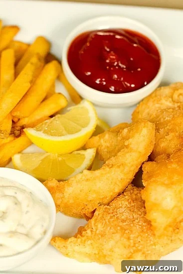 A close-up shot of a golden brown, perfectly crispy beer battered cod fillet, showcasing its tempting texture and a hint of steam rising, ready to be enjoyed.