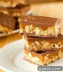Stack of 3 homemade Snickers bars on a white plate.