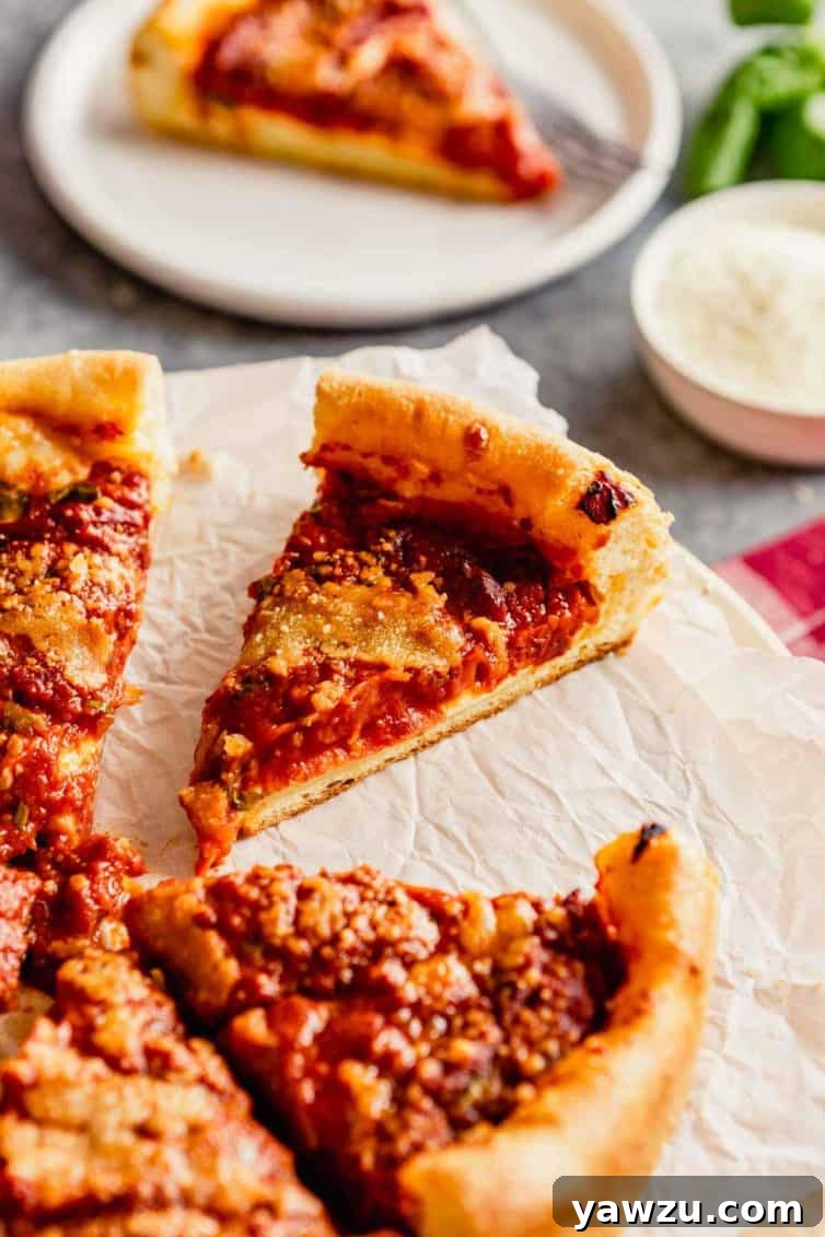 A freshly baked Chicago-style deep-dish pizza on parchment paper, with a golden-brown crust and a rich red sauce visible. A single slice has been carefully removed, showcasing the generous layers of melted cheese and toppings within.