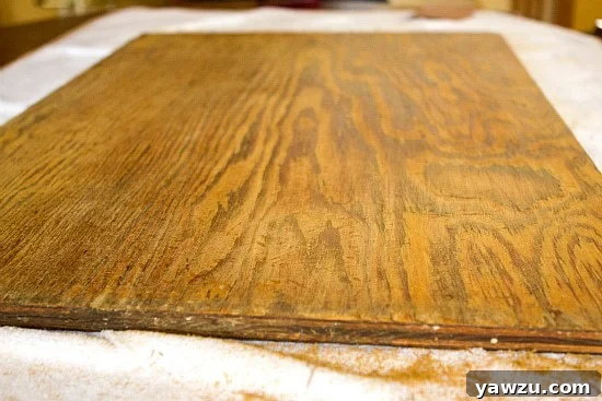 Wooden dough board after the initial stage of sanding with coarse sandpaper, showing a significantly smoother and more uniform surface