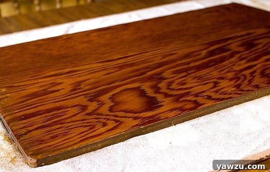 Hands meticulously massaging beeswax cream into a wooden dough board using small circular motions, creating a protective and smooth finish
