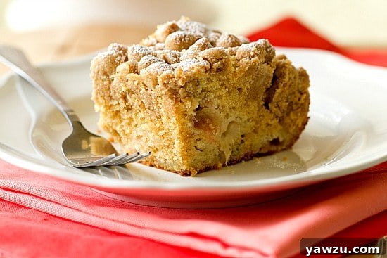 A close-up view of the baked Rhubarb Crumb Cake, showcasing its fluffy interior and thick, golden crumb topping.