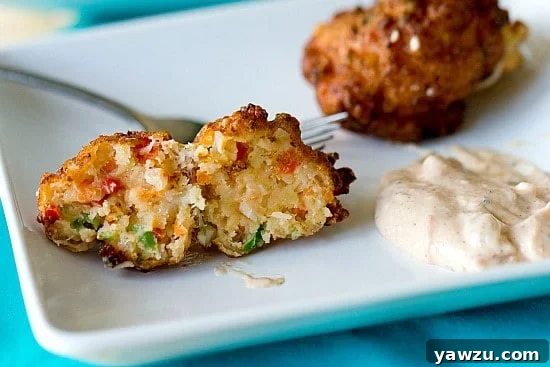 Close-up of freshly prepared conch fritters on a platter, ready to be served, with a subtle background blur.