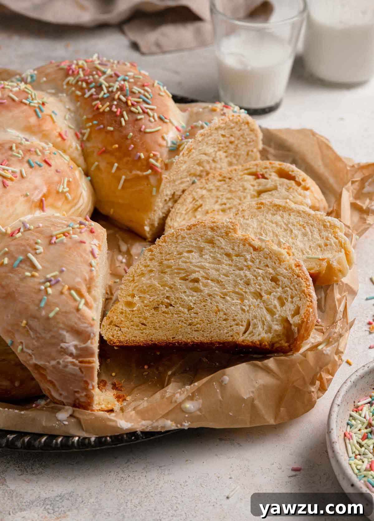 Slices of Italian Easter bread laying on a parchment-lined serving tray next to the remaining whole loaf.