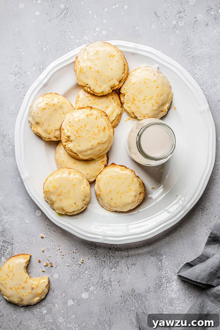 An inviting overhead photo of freshly baked orange cookies artfully arranged on a plate, accompanied by a glass of milk.