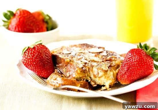 Stack of freshly made Cinnamon-Almond French Toast with syrup and powdered sugar