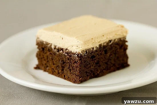 A close-up of a single mocha brownie square, showing the luscious espresso frosting swirled on top, inviting a bite.