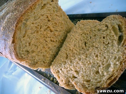 A beautifully sliced loaf of Anadama bread, showcasing its rich, dark interior and unique texture, with a single slice removed to highlight the crumb.