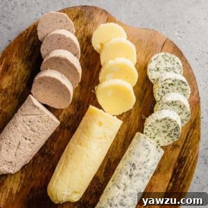 Three different compound butters cut in slices on a wooden cutting board.