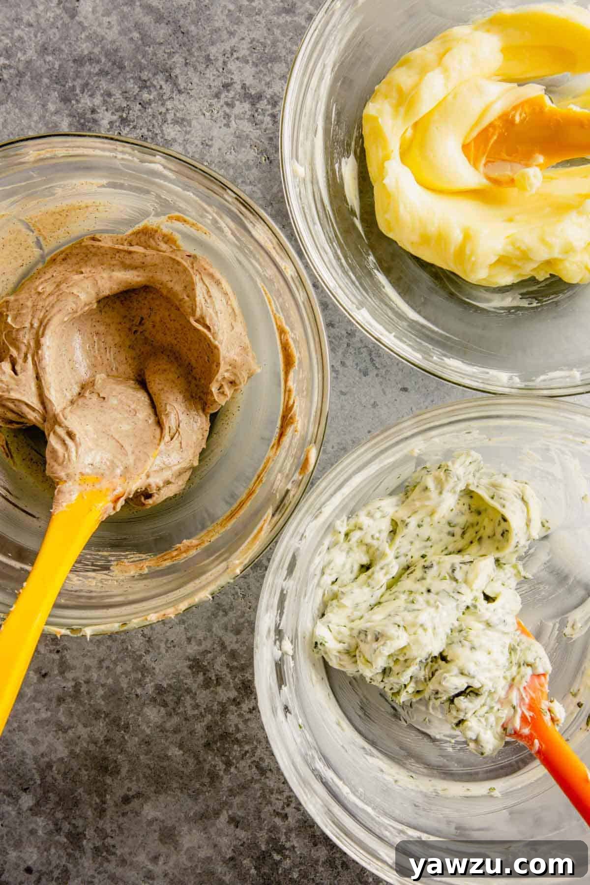 Three bowls of compound butter, each mixed to a smooth, creamy consistency with its respective flavorings.