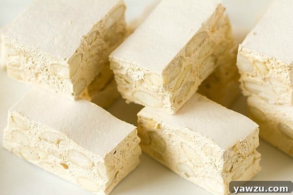 Close-up of homemade torrone with visible almonds and nougat texture.