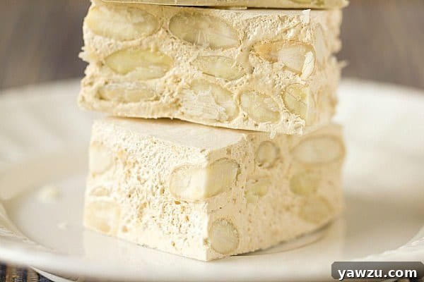 A selection of homemade torrone pieces arranged on a cutting board.