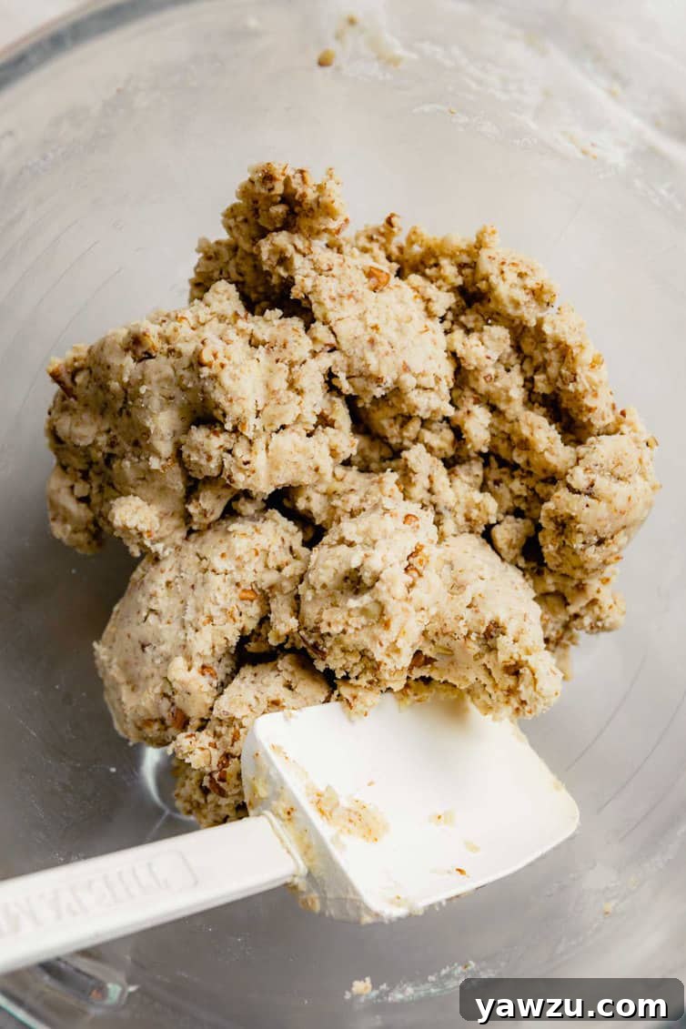 Close-up of snowball cookie dough mixed together in a bowl before rolling.