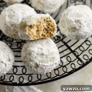 Snowball Cookies on a serving dish, perfectly dusted with powdered sugar.