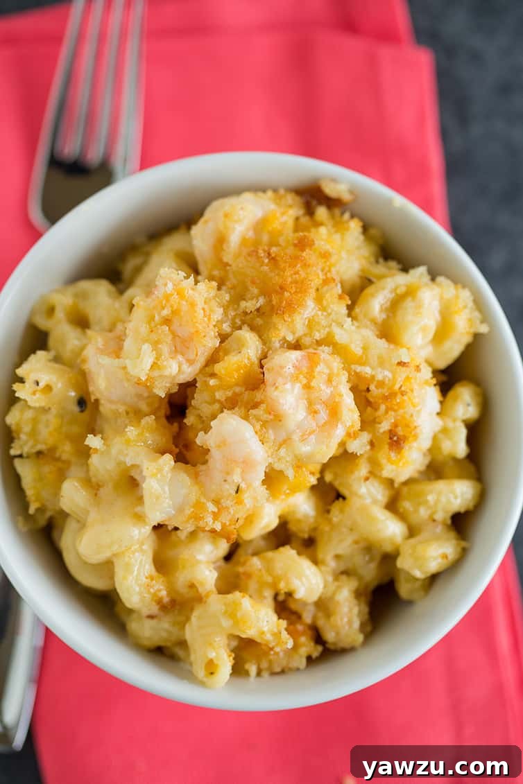 A large bowl brimming with piping hot Cajun shrimp macaroni and cheese, topped with golden bread crumbs and ready to be served.