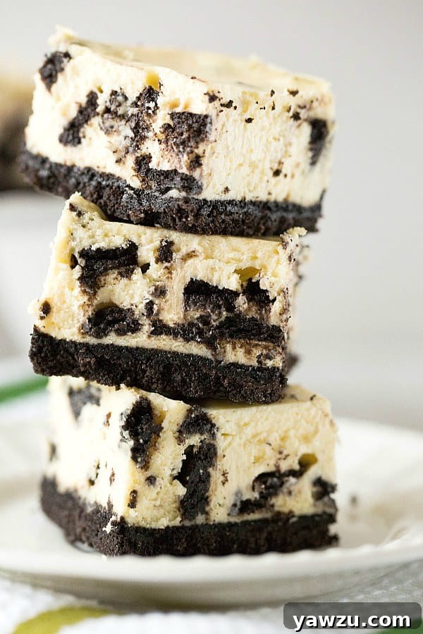 Overhead shot of freshly baked Oreo Cheesecake Bars, showcasing their golden-brown crust and smooth, speckled cheesecake topping.