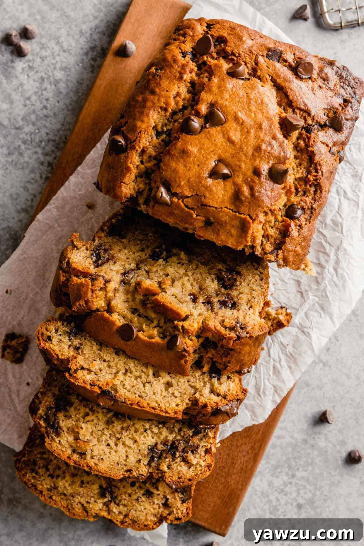 Overview photo of moist peanut butter banana bread with four slices cut off, showcasing its rich texture and chocolate chips.