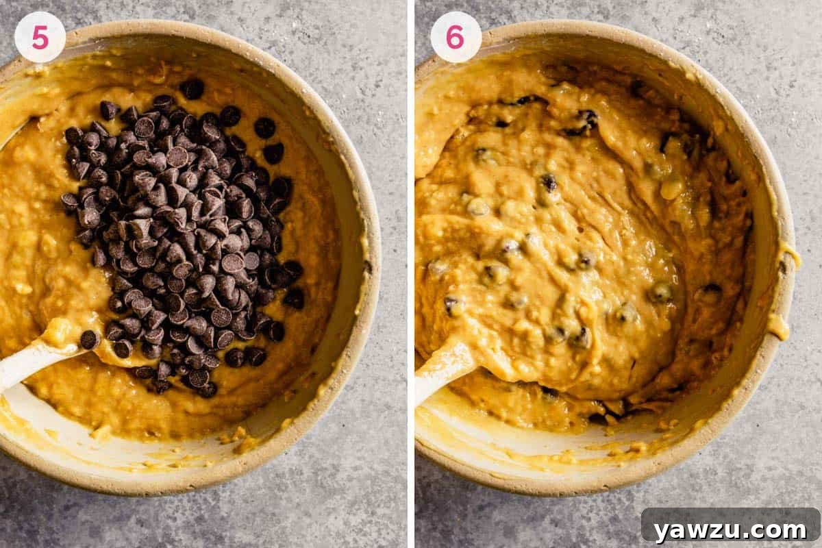 Stirring chocolate chips into a bowl of peanut butter banana bread batter with a rubber spatula.