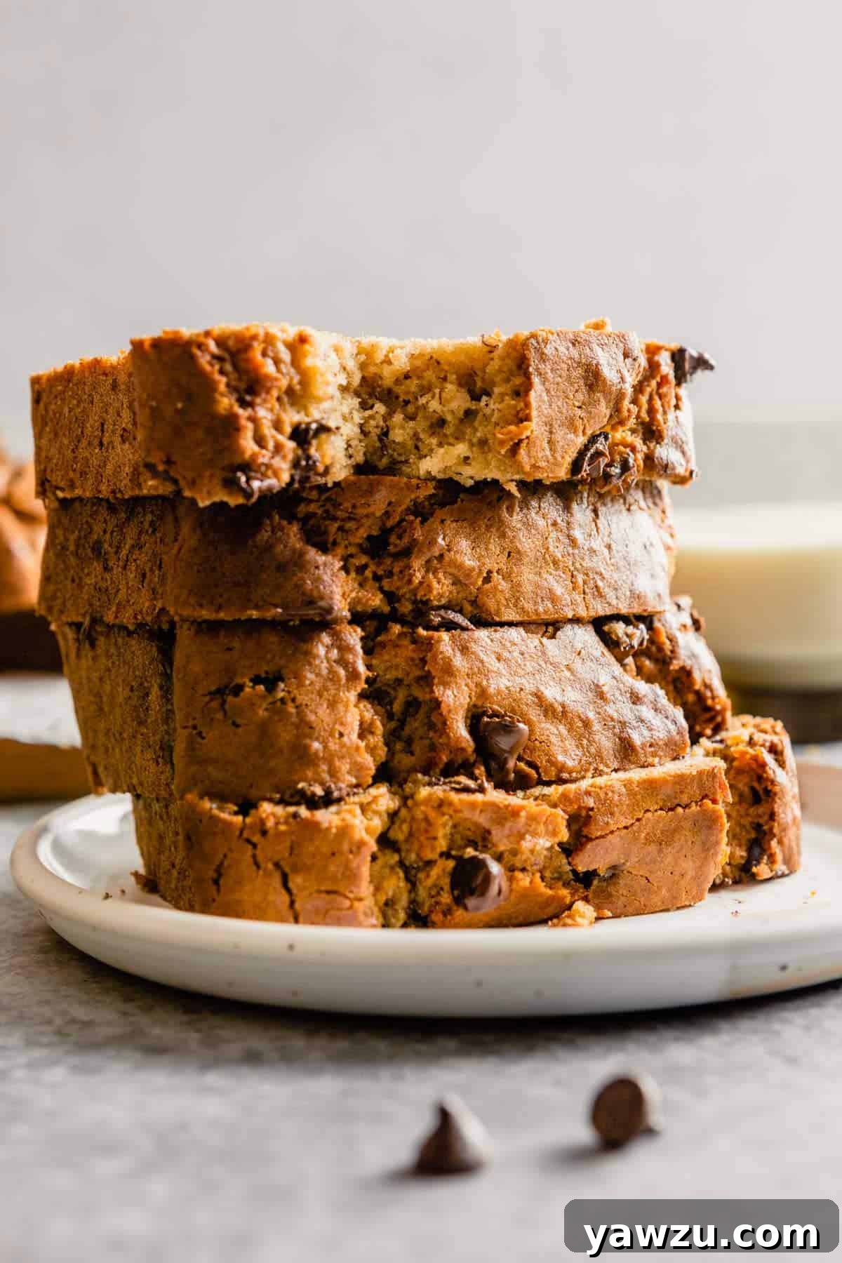 A stack of slices of peanut butter banana bread on a white plate, ready to be served.