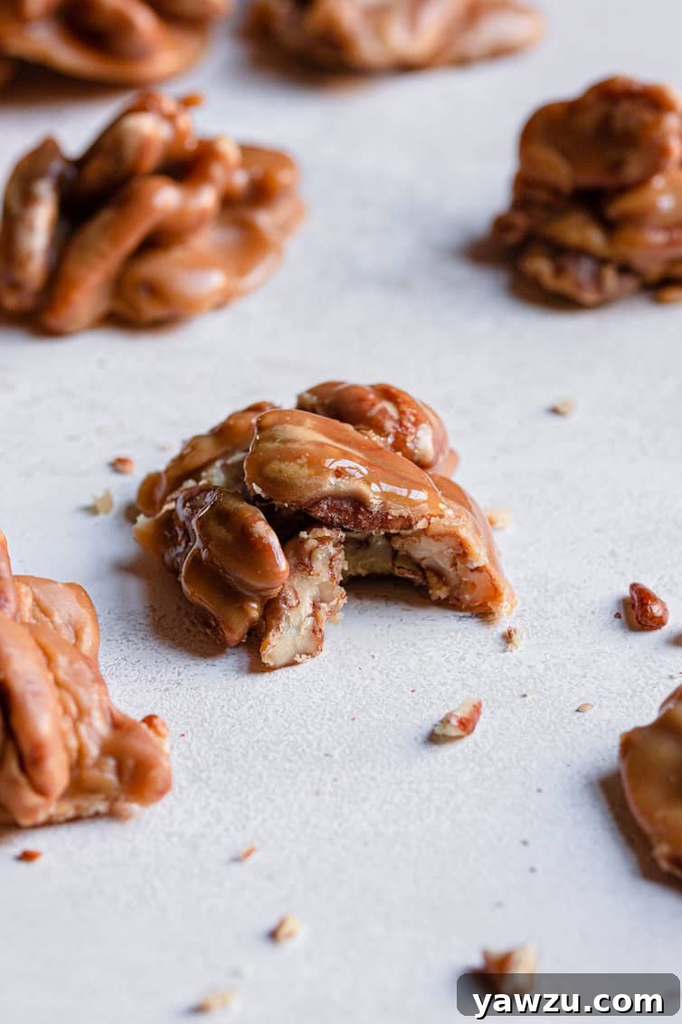 A pecan praline with a bite taken out, revealing its creamy, nutty interior and appealing texture.