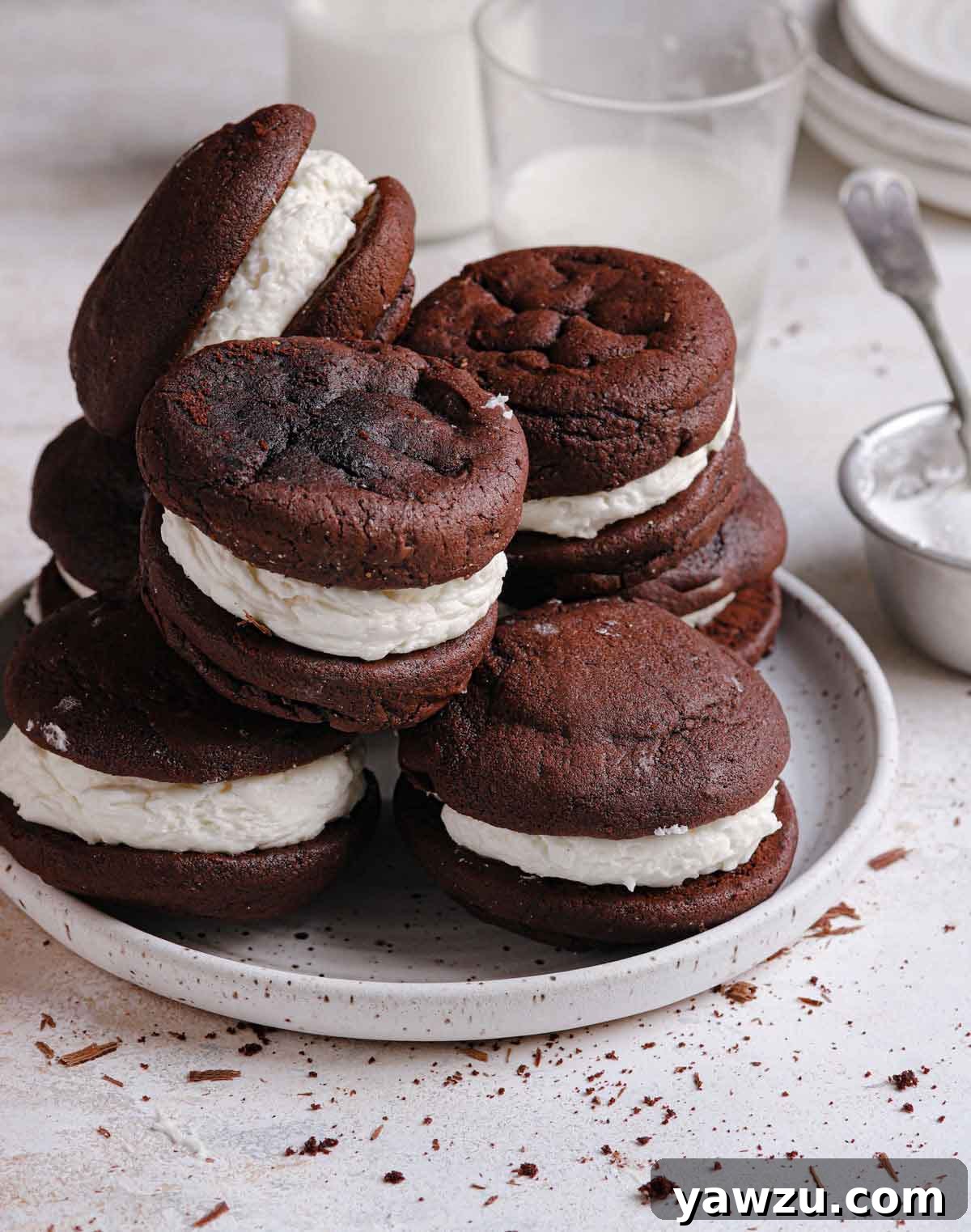 Multiple gobs stacked on top of each other on a small white speckled plate, showcasing their inviting texture and generous filling.