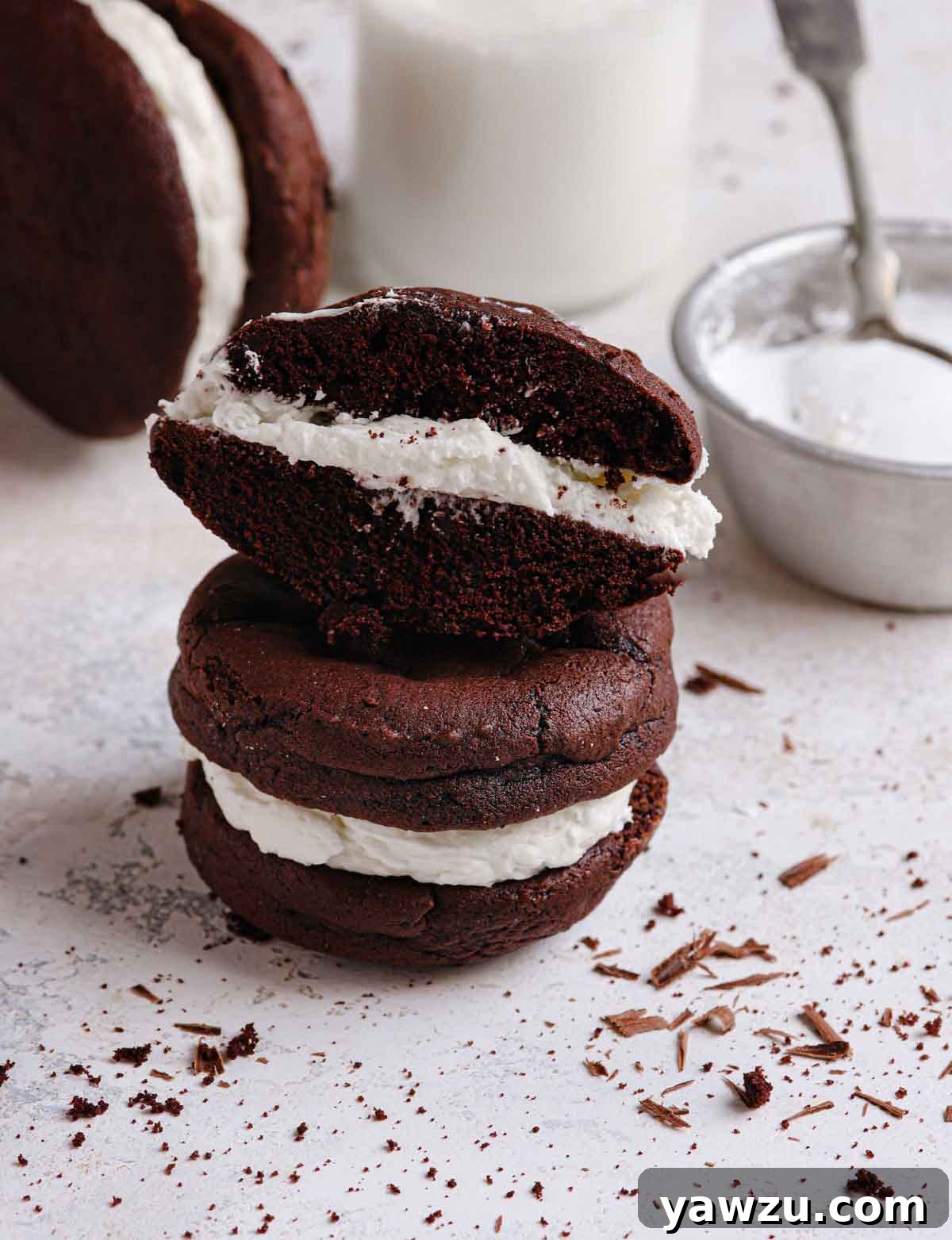 Close up photo of chocolate gob cut in half, revealing the soft cookie and generous white filling.
