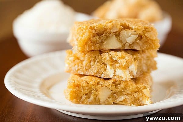 Close-up of freshly baked Macadamia Nut, Coconut & White Chocolate Blondies with a cracked, golden top