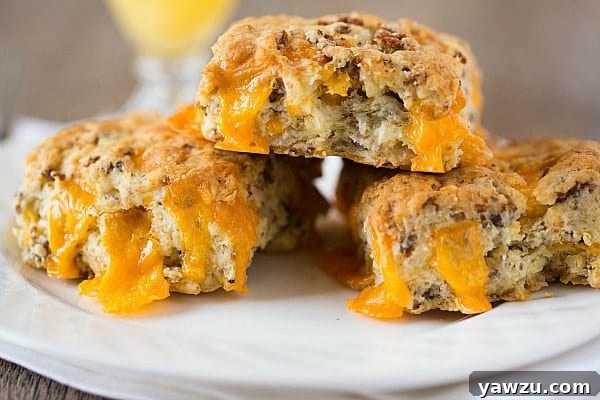Sausage-Cheddar Biscuits stacked on a serving plate, ready to enjoy