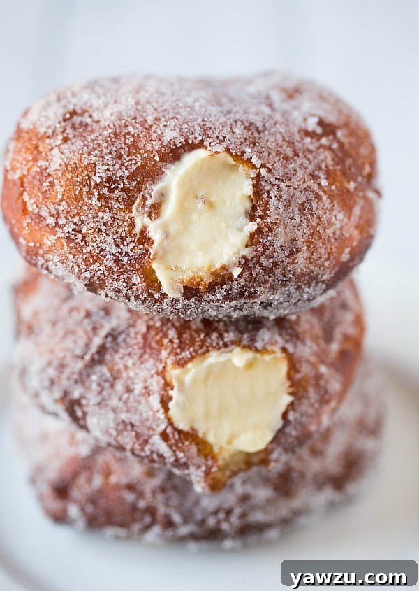 Vanilla Cream-Filled Doughnuts showing a cross-section of the creamy filling