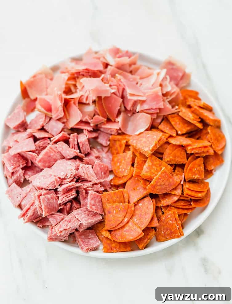 A plate of neatly chopped pepperoni, salami, and prosciutto, ready to be incorporated into the rich filling of an Italian Easter Pie.