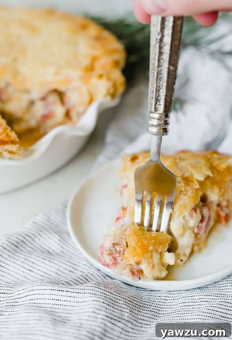 A fork digging into a generous slice of Italian Easter Pie, revealing the abundant layers of meat and cheese within its flaky crust, inviting a taste.