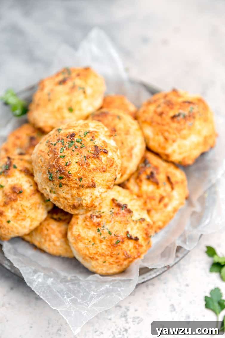 A generous bowl filled with freshly baked Red Lobster style Cheddar Bay Biscuits, golden brown and inviting.