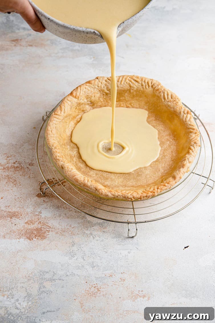 Pouring buttermilk pie filling into crust.