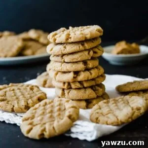 A close-up shot of a freshly baked peanut butter cookie, highlighting its golden color and the iconic crisscross pattern.
