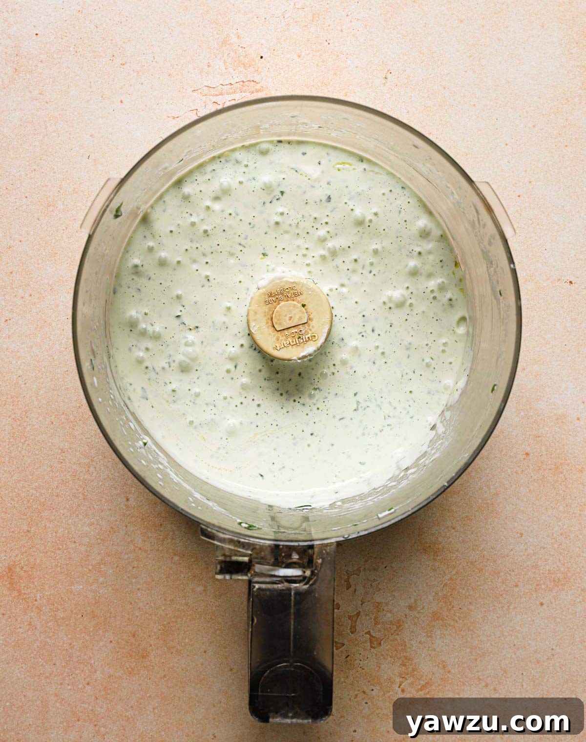 Freshly mixed homemade buttermilk ranch dressing in a food processor bowl.