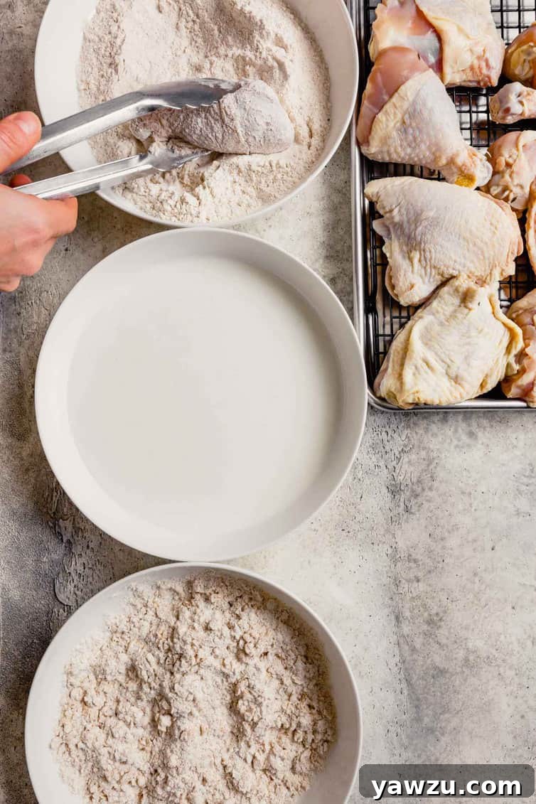 Chicken dredging station with flour mixture at the top, buttermilk in the middle, and shaggy dredge at the bottom.