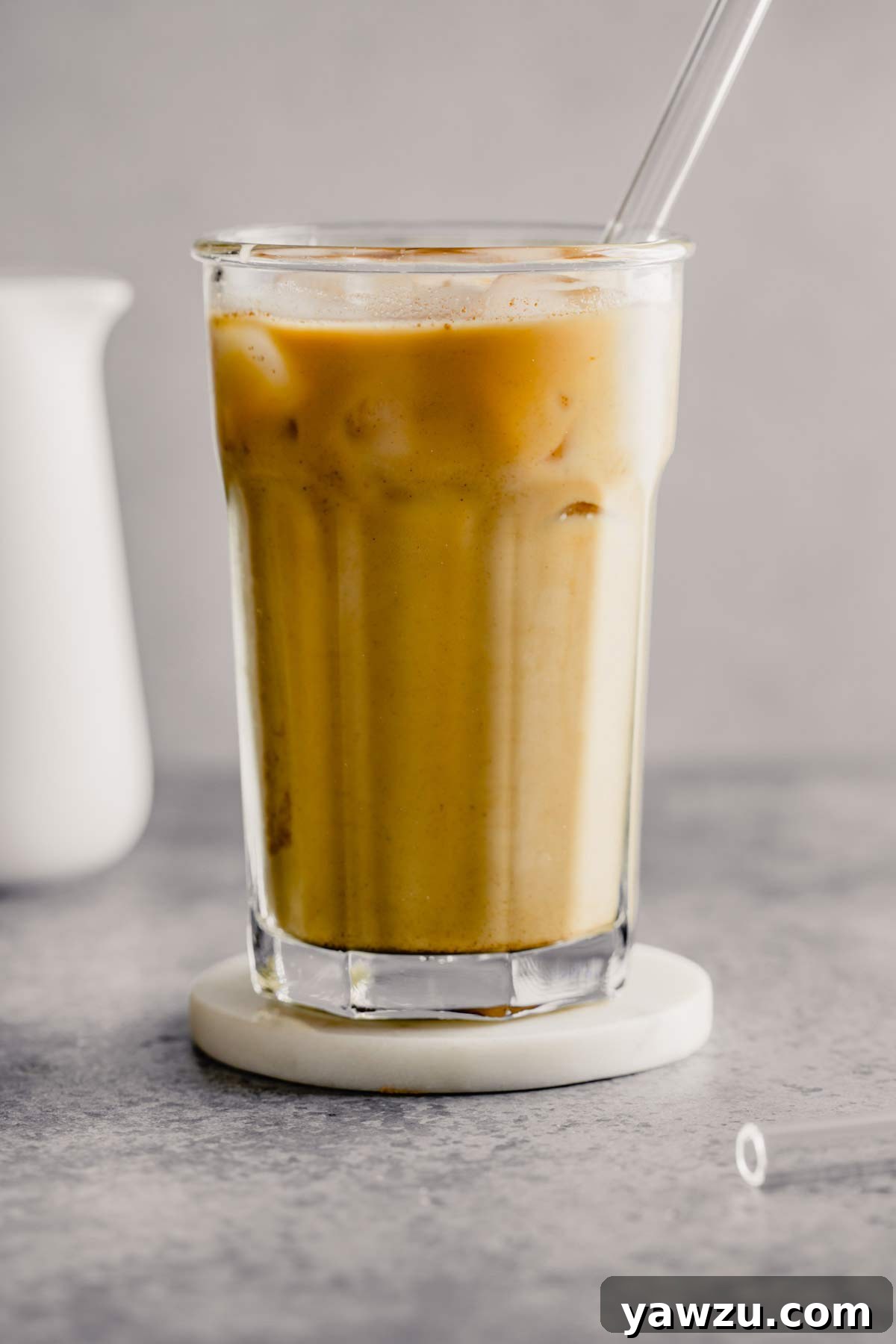 A refreshing glass of homemade iced coffee with a simple plastic straw, ready to be enjoyed.