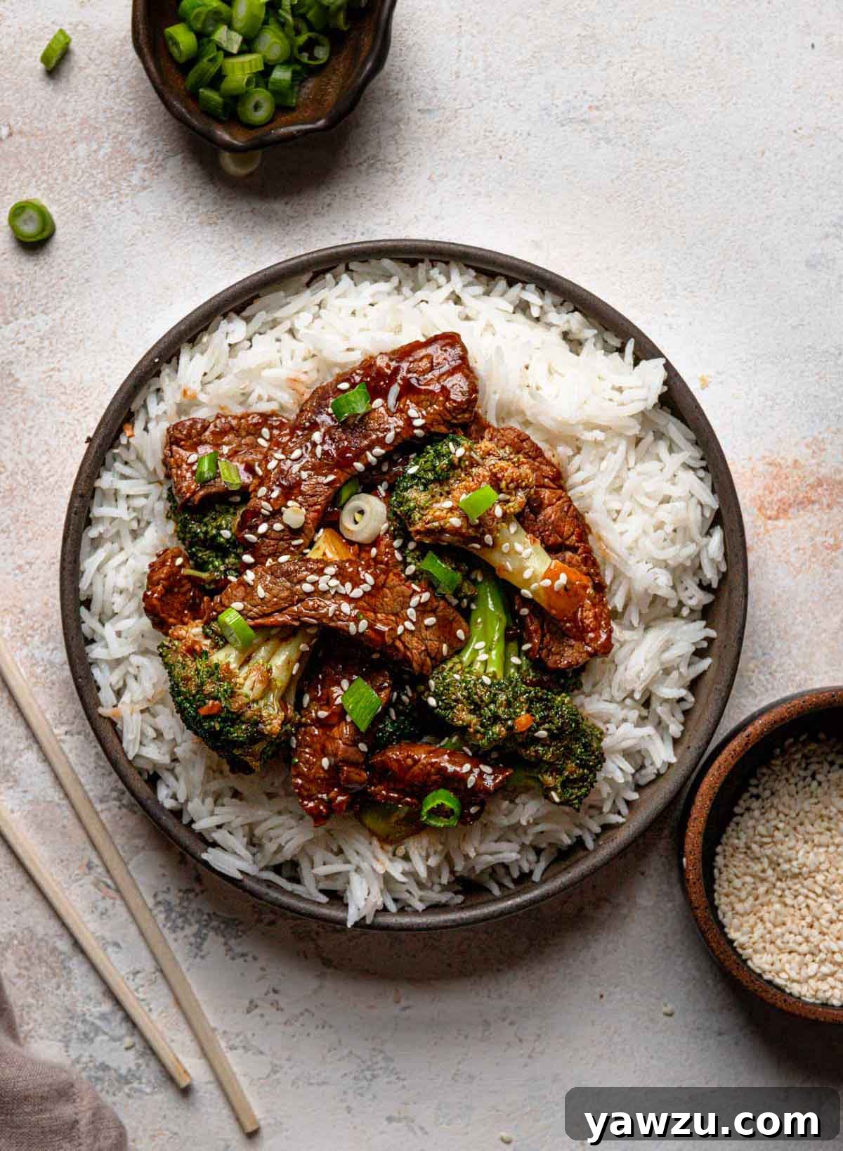 Overhead photo of beef and broccoli stir fry generously served over fluffy white rice, ready to eat.