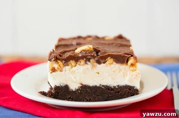 Homemade chocolate fudge topping being drizzled over frozen brownie sundae