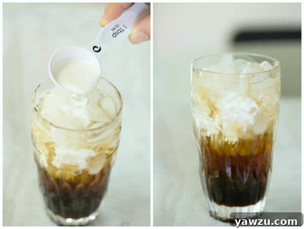 Creamy half-and-half being poured into the chocolate-infused club soda, creating elegant white swirls and marbling effects.