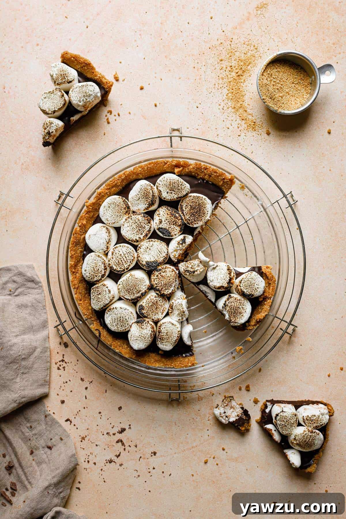 No bake s'mores pie on a wire cooling rack with a slice on the counter in the top left and bottom right.