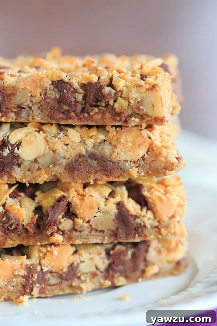 Delicious Seven Layer Bars, also known as Magic Bars, showcasing the layers of graham cracker crust, nuts, various chocolate chips, coconut, and sweetened condensed milk.