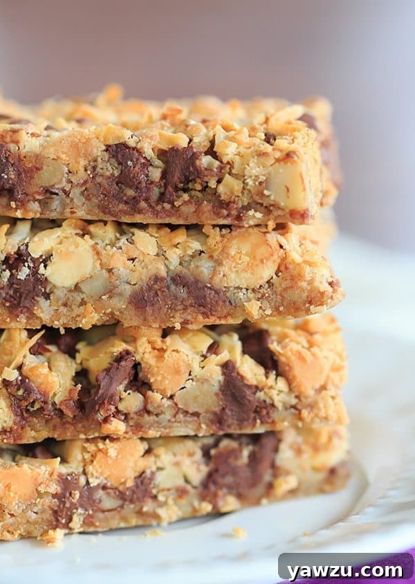 Close-up of baked Seven Layer Bars, showing the golden-brown toasted coconut and melted chips. Perfect for a sweet treat.